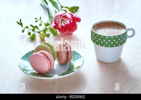 Frühjahr/Hintergrund. Rosa Tulpe, freesie, Espresso und macarons in Front, Frühlingsblumen in den Rücken. Stockfoto