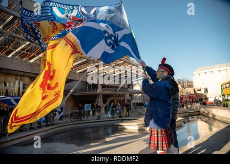 Ein Demonstrator wird gesehen, die eine Flagge vor dem Schottischen Parlament Gebäude während eines Flash protestieren. Die Demonstranten versammelten sich vor Gebäude des schottischen Parlaments in Edinburgh Brexit zu protestieren und für eine zweite unabhängigkeitsreferendum zu drücken. Stockfoto