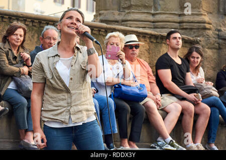 Straßenmusikanten, die eine spektakuläre Show auf der Piazza della Signoria vor einer Masse in Florenz, Italien. Stockfoto