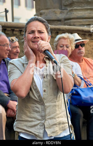 Straßenmusikanten, die eine spektakuläre Show auf der Piazza della Signoria vor einer Masse in Florenz, Italien. Stockfoto