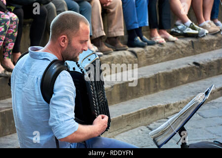 Straßenmusikanten, die eine spektakuläre Show auf der Piazza della Signoria vor einer Masse in Florenz, Italien. Stockfoto