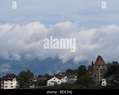 Steiniger Turm und schöne Siedlung auf einem Hügel im Stadtbild Landschaften von Wolken über europäische Hauptstadt Vaduz, Liechtenstein mit bewölktem Himmel in 2 Stockfoto