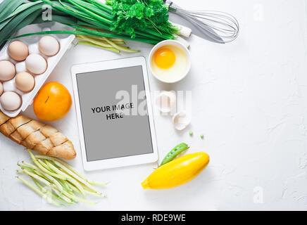 Rezepte Kochen auf dem Ipad mit Gemüse auf Hintergrund, kopieren Raum Stockfoto
