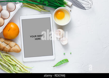 Rezepte Kochen auf dem Ipad mit Gemüse auf Hintergrund, kopieren Raum Stockfoto