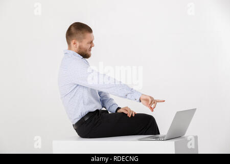 Junger stattlicher Mann mit Laptop in Hemd und Krawatte Stockfoto