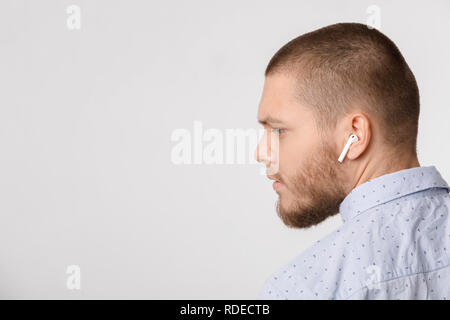 Ruhe bärtiger junger Geschäftsmann nutzt drahtlose Kopfhörer. Stockfoto