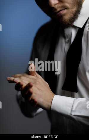 Die Hände der Jungen bärtigen Mann im Hemd und ungebundene Bow Tie Stockfoto