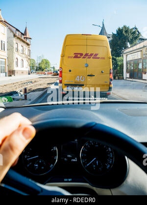 FRANKFURT, Deutschland - 17.April 2018: Fahrer Sicht auf der Straße halten Sie das Lenkrad mit der Hand fahren vor DHL Deutsche Post Lieferung van - Paketversand Stockfoto