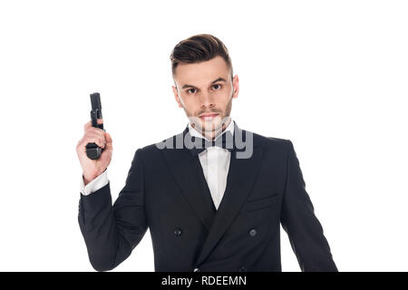 Stattliche Secret Agent im schwarzen Anzug und Krawatte Bug holding Pistole, isoliert auf weißem Stockfoto