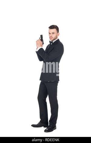 Elegante Secret Agent im schwarzen Anzug holding Gun, isoliert auf weißem Stockfoto