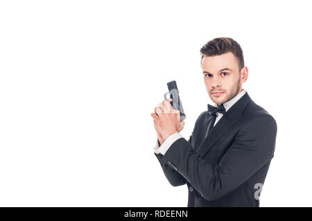 Stattliche Secret Agent im schwarzen Anzug holding Gun, isoliert auf weißem Stockfoto