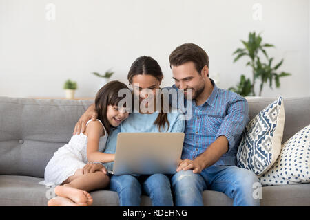Glückliche Familie mit Kind Mädchen Spaß mit Laptop zusammen Stockfoto