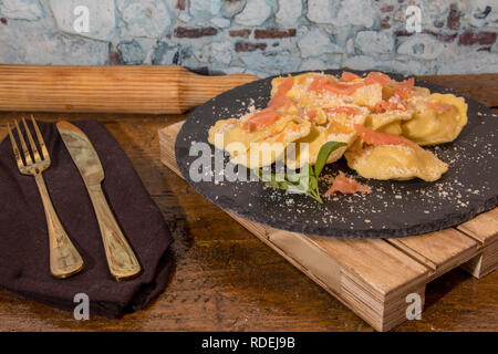 Gefüllte Nudeln mit Lachs auf einen schwarzen Stein Platte Stockfoto