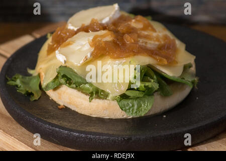 Vegan Hamburger mit Käse und Ketchup auf schwarzen Holzplatte Stockfoto