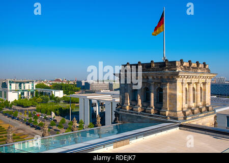 Berlin, Berlin/Deutschland - 2018/07/31: auf der Dachterrasse des Reichstagsgebäudes mit dem historischen Eckturm und Deutschland Fahne mit Berliner Skyline Stockfoto