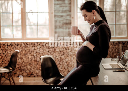 Positive schwangere Frau auf ihrem Bauch Stockfoto