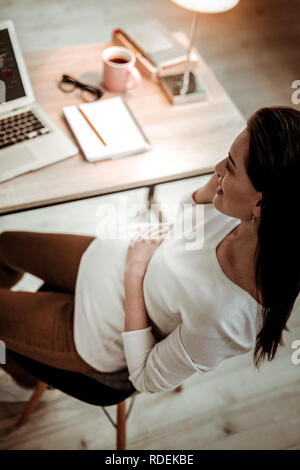 Blick von oben auf eine positive Schwangere Frau am Telefon zu sprechen Stockfoto