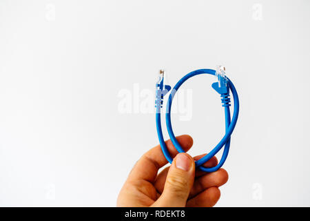 Mann hält in der Hand gegen den weißen Hintergrund blau Ethernet Kabel Internet auf schnelle Gigabit Internet Netzwerk zu verbinden Stockfoto