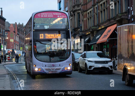 Doppeldeckerbus fährt eine Straße im Stadtzentrum in Leeds, West Yorkshire, England, Großbritannien. Stockfoto