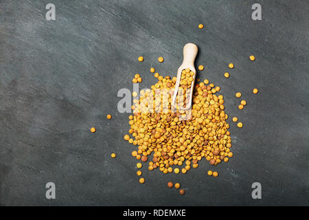 Roh Linsen auf Schwarz Stein Hintergrund. Gesunde vegetarische Essen Konzept. Superfoods. Ansicht von oben, kopieren. Linsen sind reich an komplexen Kohlenhydraten, f Stockfoto