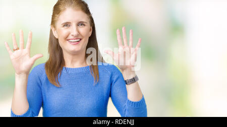 Schöne, reife Frau mittleren Alters tragen winter Pullover über isolierte Hintergrund angezeigt und zeigen mit den Fingern Nummer zehn, während lächelnd confid Stockfoto