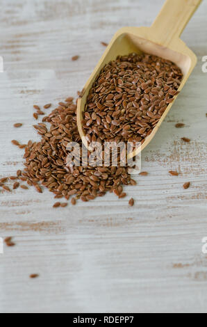 Brauner Leinsamen in hölzernen Löffel auf weißem Hintergrund. Stockfoto