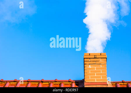 Modernes Haus mit Schornstein rauchen, Luftverschmutzung und Smog in Winter, ökologische Probleme Stockfoto