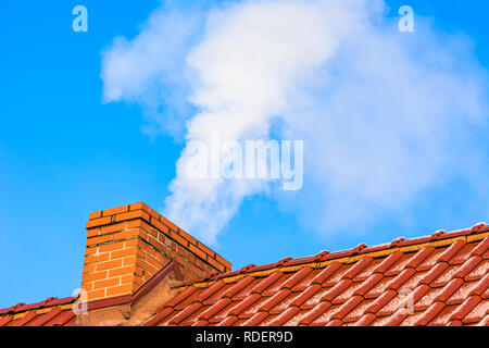 Modernes Haus mit Schornstein rauchen, Luftverschmutzung und Smog in Winter, ökologische Probleme Stockfoto