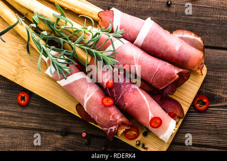 Grissini Stick von Brot mit Schinken, italienisches Essen platter mit Antipasti auf Holztisch, Overhead, flatlay Stockfoto