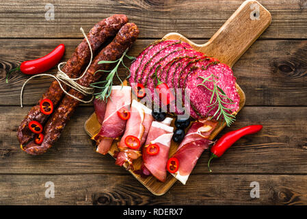 Traditionelle spanische Tapas Bar Essen auf Platter, Auswahl an kaltem Fleisch, Wurst, Chorizo, Salami Scheiben, Schinken Prosciutto auf hölzernen Tisch Stockfoto