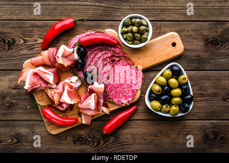 Kalte Fleischplatte mit Salami, Scheiben Schinken Prosciutto, italienischen Antipasti auf Holzbrett Stockfoto