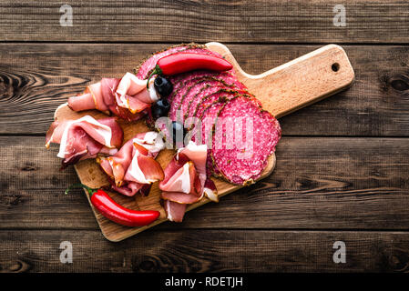 Kalte Fleischplatte mit Salami, Scheiben Schinken Prosciutto, italienischen Antipasti auf Holzbrett Stockfoto