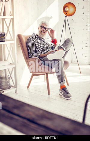 Gerne bärtiger Mann im eleganten Sessel sitzen Stockfoto