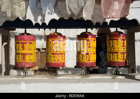 Nahaufnahme von roten und gelben Buddhistischen Gebetsmühlen auf ein mani Mauer in Lo Mantang, Upper Mustang, Nepal. Stockfoto