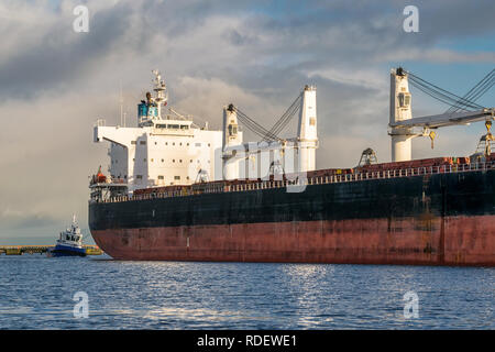 Ein Bild von einem Schiff in den Hafen von einem Schlepper gezogen wird, Stockfoto