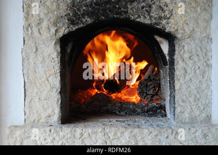 Die traditionellen Holzofen. Brennen Flammen im Kamin Stockfoto