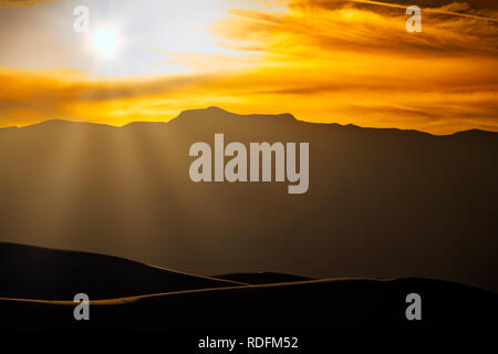 Die Sonne hinter den Bergen in der Nähe von Alamogordo, New Mexico. Stockfoto