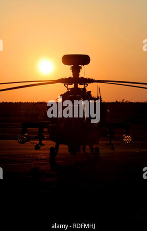 Army Air Corps Apache AH1 Hubschrauber gegen die untergehende Sonne silhouetted, wie es auf den Woodbridge airfield während der Übung eingesetzten sitzt. Stockfoto