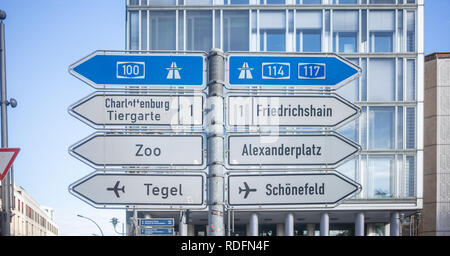 Schilder mit Pfeile zeigen die wichtigsten Richtungen der Berlin, Deutschland. Blauer Himmel und Glas Fenster Gebäude Hintergrund. Stockfoto