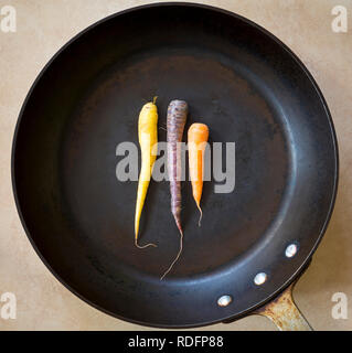 Mehrfarbige Karotten in einer großen schwarzen Bräter Stockfoto