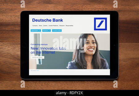 Die Website der Deutschen Bank ist gesehen auf einem iPad Tablet, der ruht auf einem Holztisch (nur redaktionelle Nutzung). Stockfoto