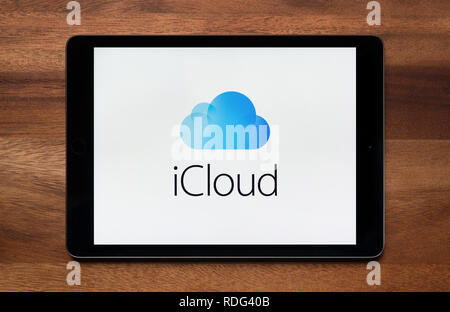 Das Logo der iCloud ist gesehen auf einem iPad Tablet, der ruht auf einem Holztisch (nur redaktionelle Nutzung). Stockfoto