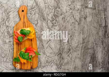 Toast mit verschiedenen Arten von Tomaten auf konkreten Hintergrund. Kopieren Sie Platz für Text. Gesundes essen Hintergrund. Top View oder flach. Stockfoto