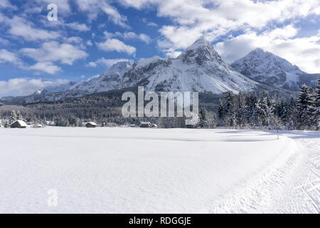 Winter Berglandschaft mit präparierten Loipen und blauer Himmel mit weißen Wolken in sonniger Tag. Ehrwalder Tal, Tirol, Alpen, Österreich. Stockfoto