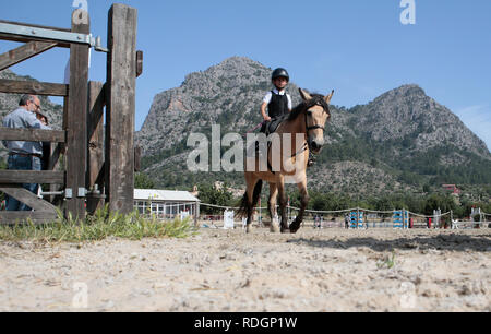 Junge Fahrer konkurrieren, die auf ihren Pferden und Ponys auf einem lokalen Pferderennen in der spanischen Insel Ma Stockfoto