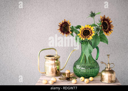 Blumenstrauß aus Sonnenblumen in einer Vase aus Glas und Messing Home Decor, auf konkreten Hintergrund mit kopieren. Stockfoto