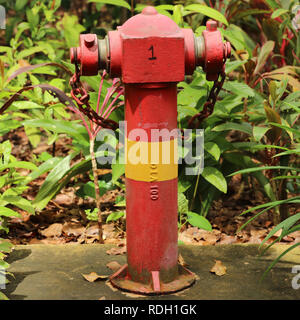 Farbcodiert rot Hydranten mit einem gelben Band in Singapur. Dieser unter hohem Druck stehende Wasser Anschlusspunkt wird über Boden und leicht zugänglich. Stockfoto