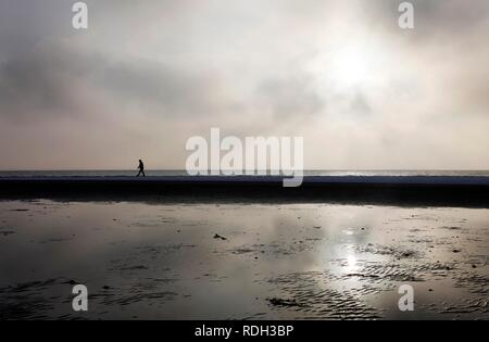 Person zu Fuß entlang der verschneiten Strand auf der ostfriesischen Nordseeinsel Spiekeroog, Niedersachsen Stockfoto