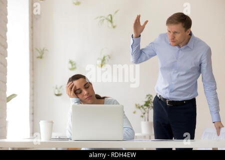 Wütend verwirrt boss Fang schlafen Mitarbeiter am Arbeitsplatz Stockfoto