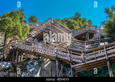 Blick auf eine Treppe auf hölzernen ausgesetzt Fußgängerweg auf Bergen, mit Blick auf den Fluss Lima, in Alvor, Portugal Stockfoto